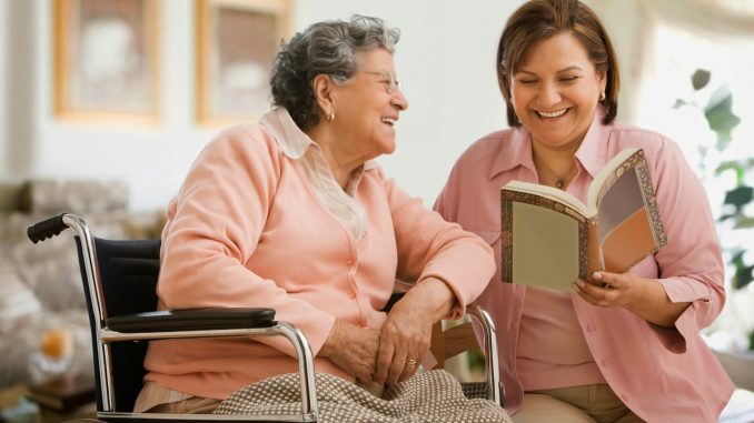 Hispanic woman reading to mother
